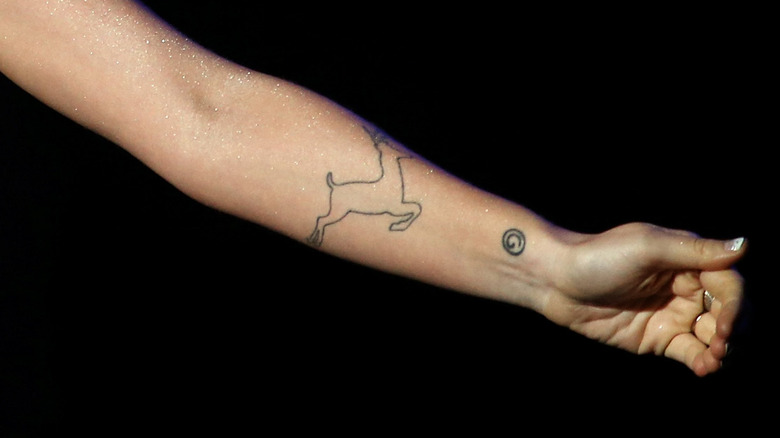 outline of a deer tattooed on woman's arm