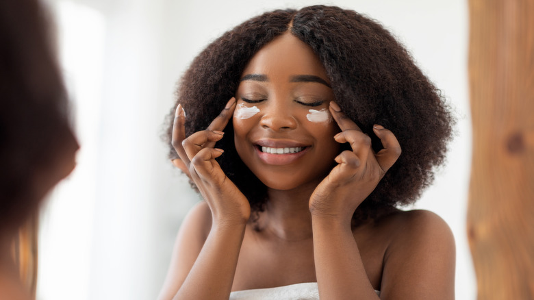 woman applying moisturizer
