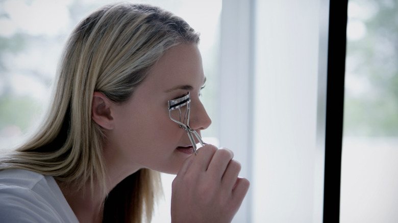 Woman using an eyelash curler