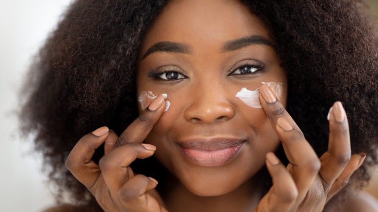 Woman applying skincare products