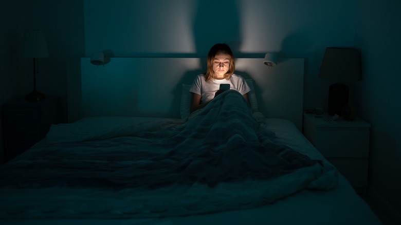 Scrolling phone in bed