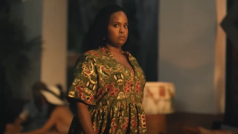 A woman walking in a long green tropical-patterned dress
