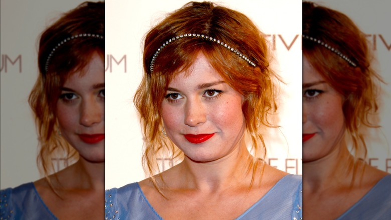 Brie Larson on the red carpet with a sparkly headband and strawberry blonde hair