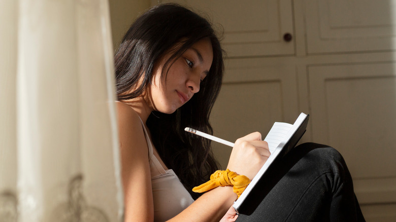 A woman smiling holding a diary