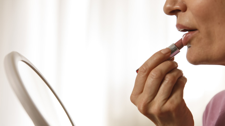 Woman applying lipstick