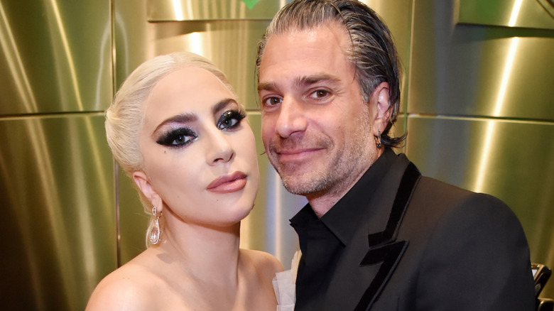 Lady Gaga in a cream dress with Christian Carino in a black suit at an event