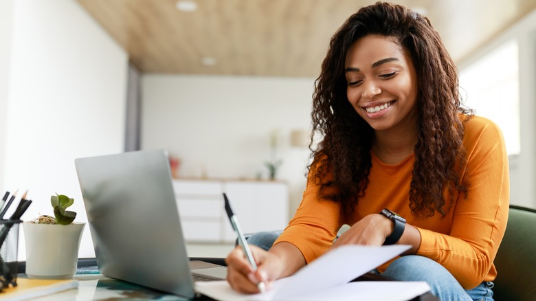 woman smiles while writing