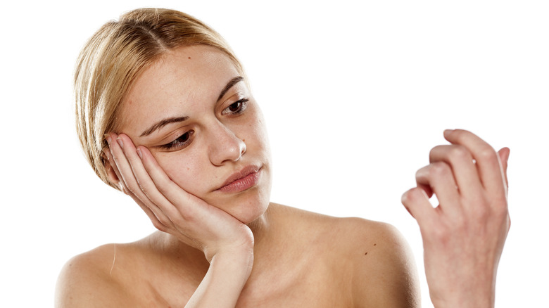 woman looking at nails
