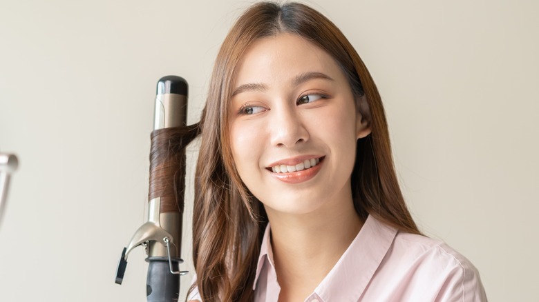 woman using hair styling tool 