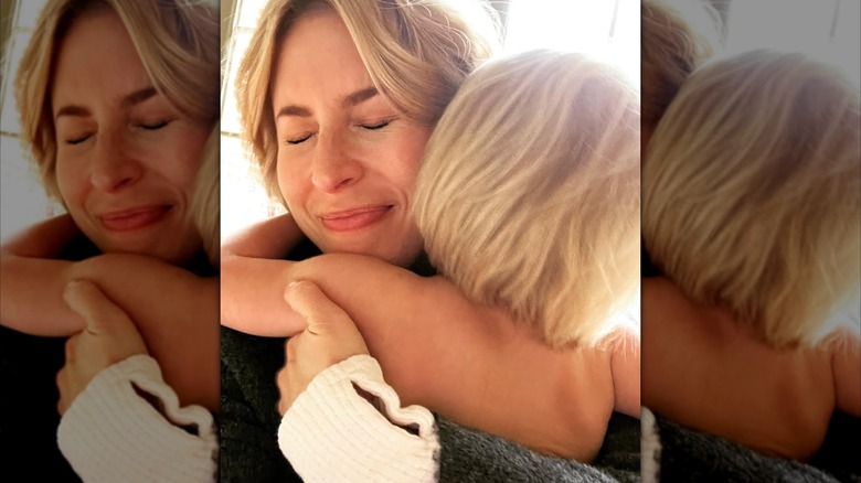 Erin Napier embracing one of her children