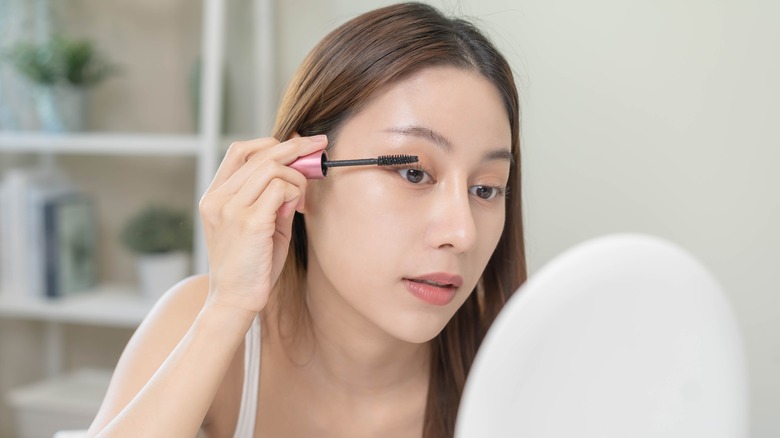 Woman applying mascara