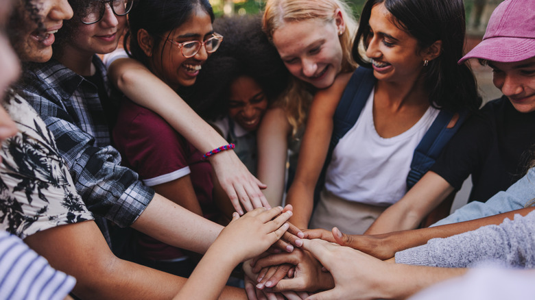 Smiling women joining hands