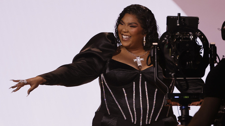 Lizzo wearing black dress, smiling 