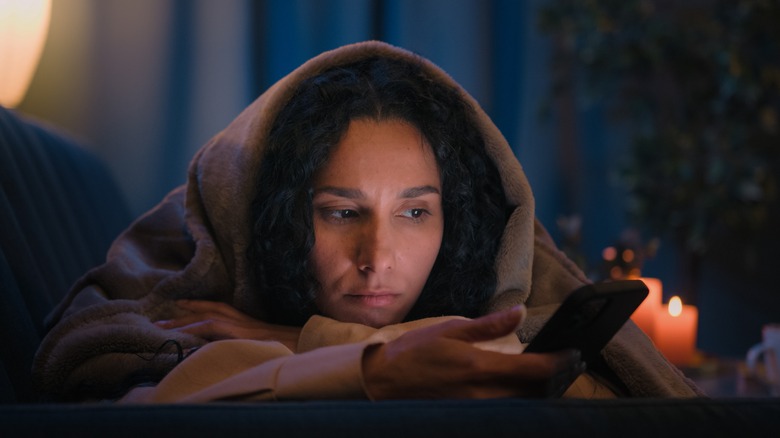 Glumly checking phone