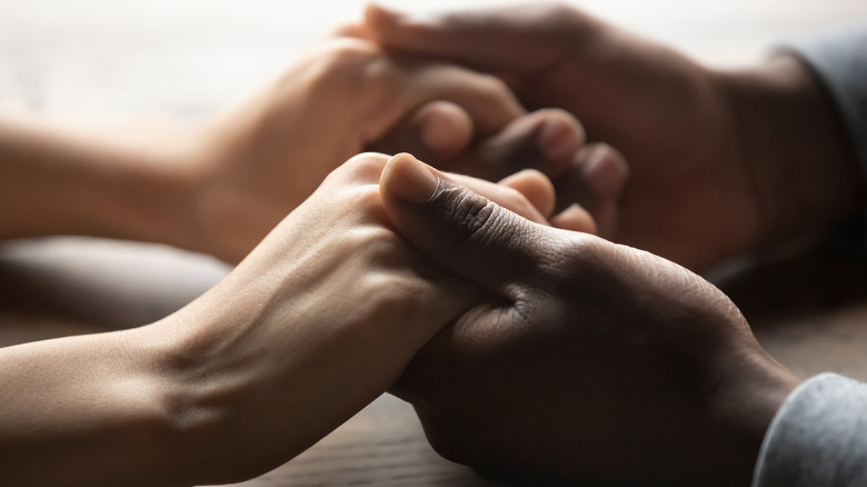 Two pairs of hands holding 