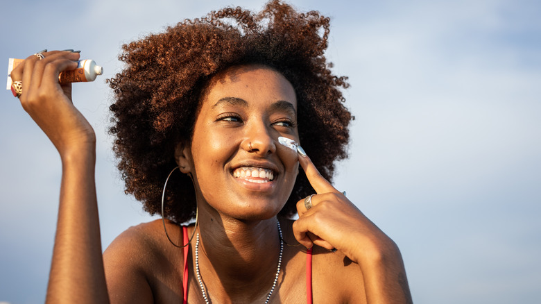 Woman applying sunscreen to her face