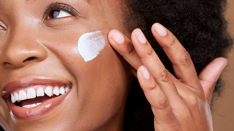 Woman applying moisturizer