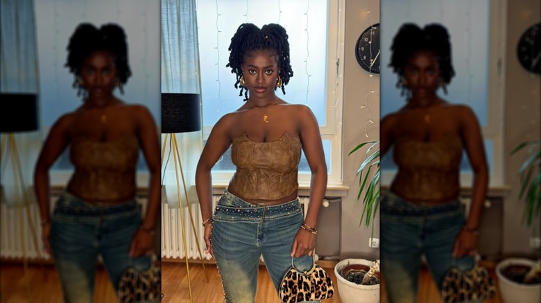 A woman wearing rhinestone jeans and a brown corset top