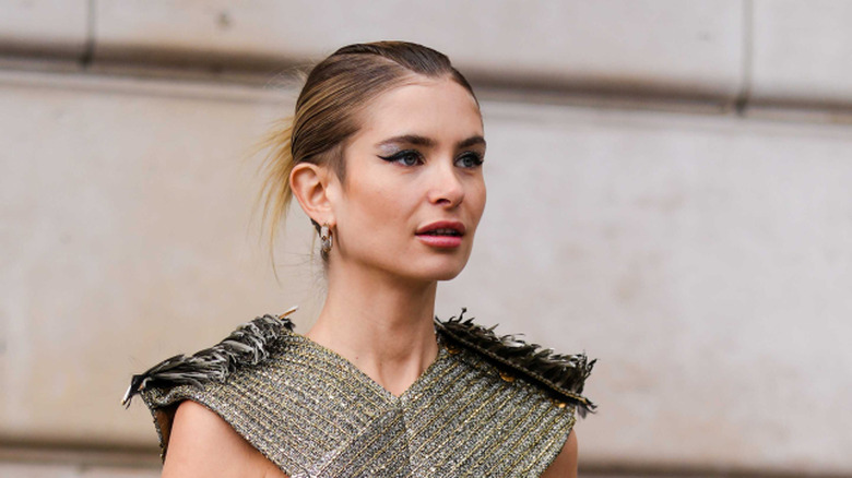 A woman with winged eyeliner and pink lipstick