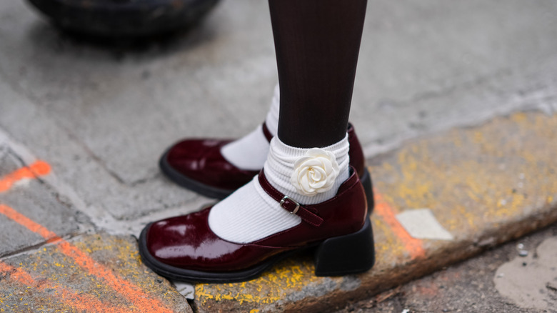 ﻿Close-up of maroon Mary Janes with a chunky heel wore with black tights and white socks