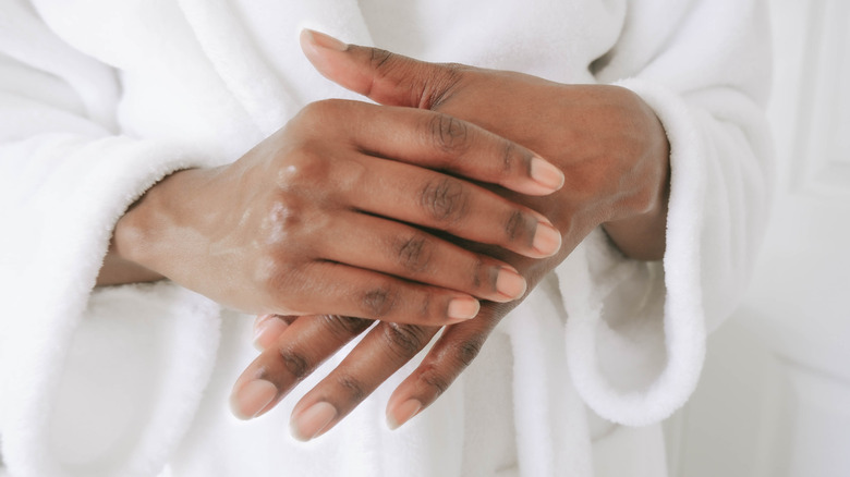Close-up of woman's hands healthy nails, rubbing in oil
