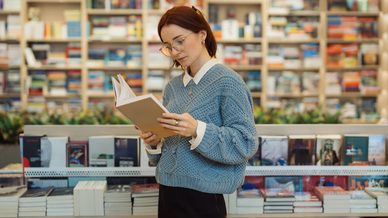 Woman reading book in a bookstore