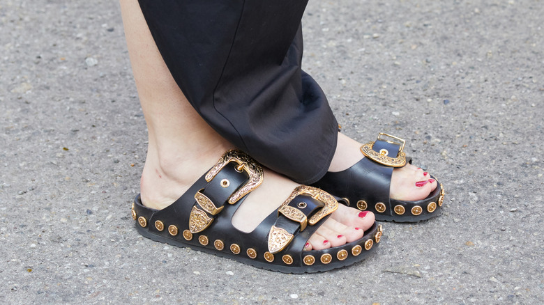 A close-up photo of an individual's feet wearing country sandals