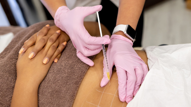 woman getting injection in stomach
