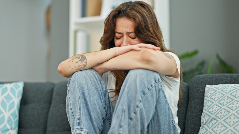 woman crying on couch