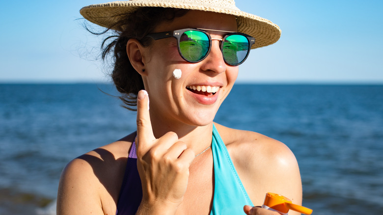 Woman applying sunscreen to face