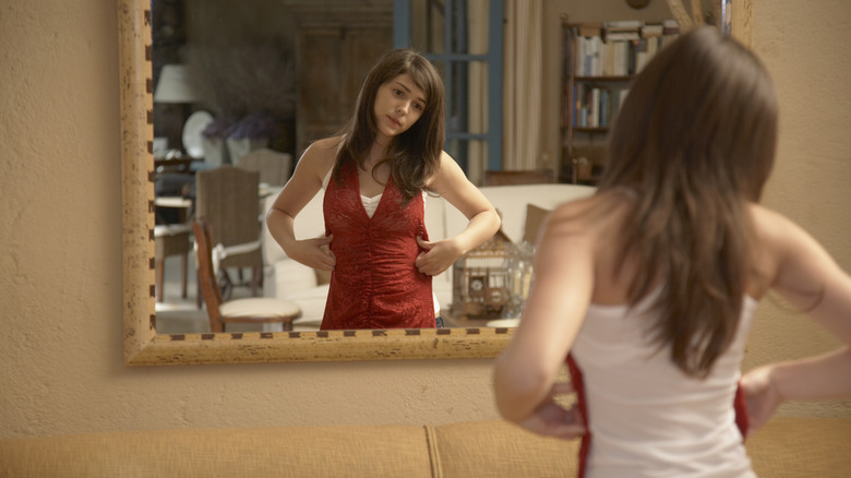 Woman trying on top in mirror