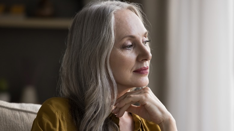 Mature woman looking out window