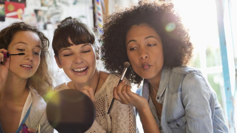 women putting on makeup