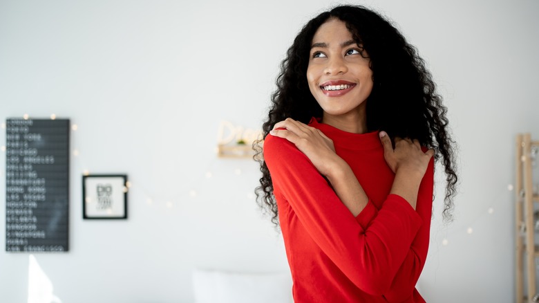 young woman embracing herself