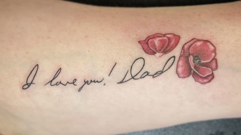 Photo of tattoo of hand-written script and flowers