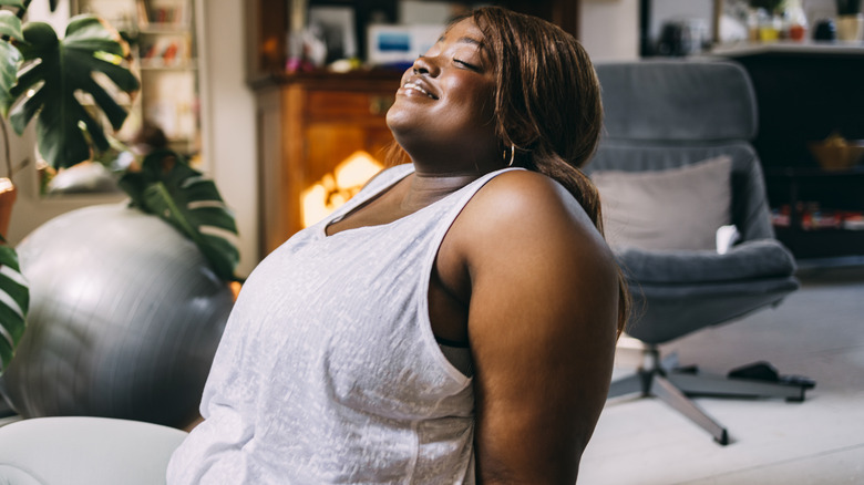 Woman smiling, stretching, and relaxing
