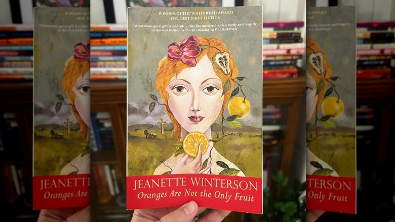 Hand holding "Oranges Are Not the Only Fruit" book