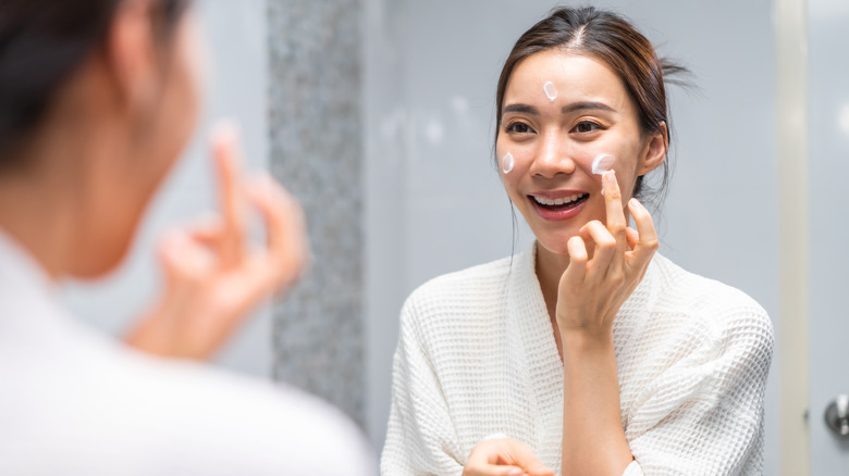 Woman applying moisturizer