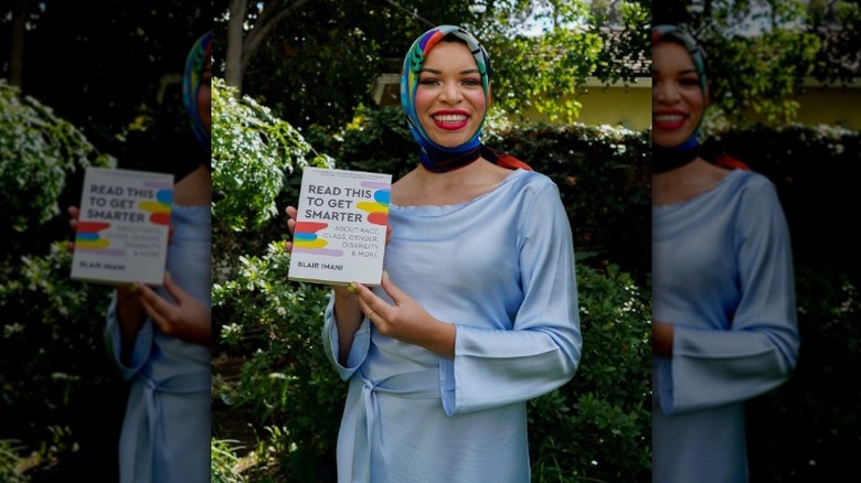 Blair Imani holding her book