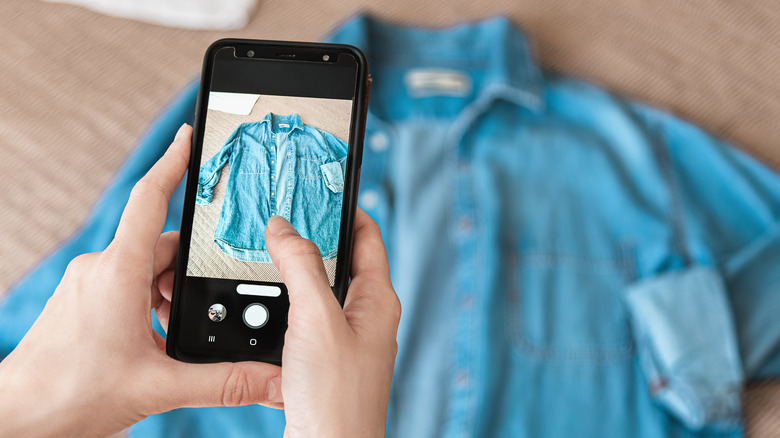 Someone taking a photo of a denim shirt