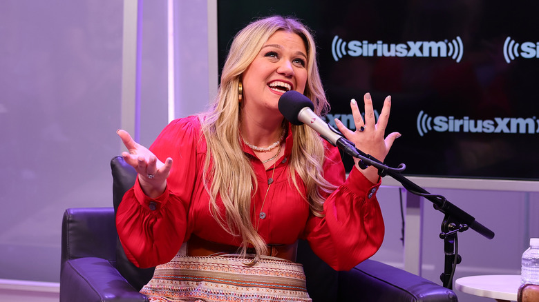 Kelly Clarkson speaking into a microphone