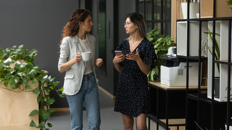 two women walking through office