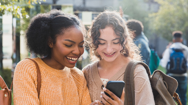 two girls laughing at phone