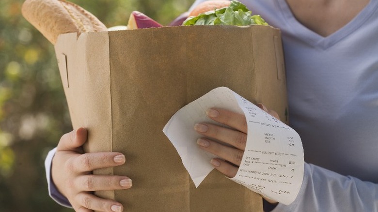Woman with groceries and receipt