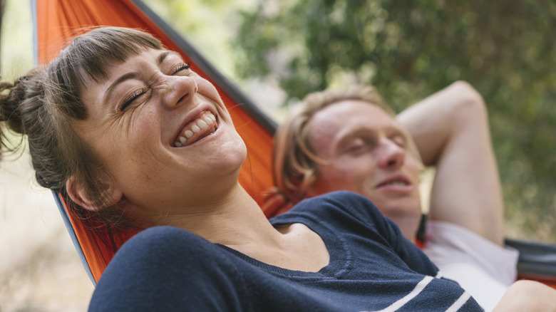 woman and man happy on a hammock