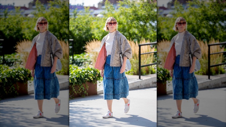 Woman wearing denim midi skirt and white sneakers