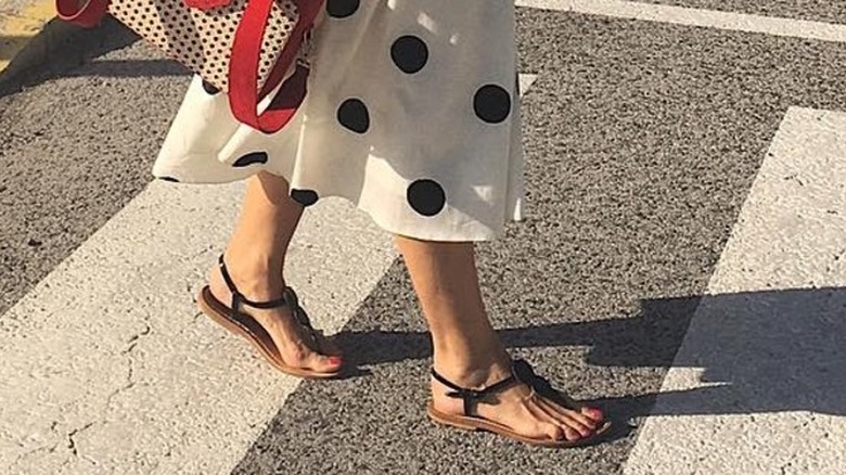 A woman wearing T-strap sandals