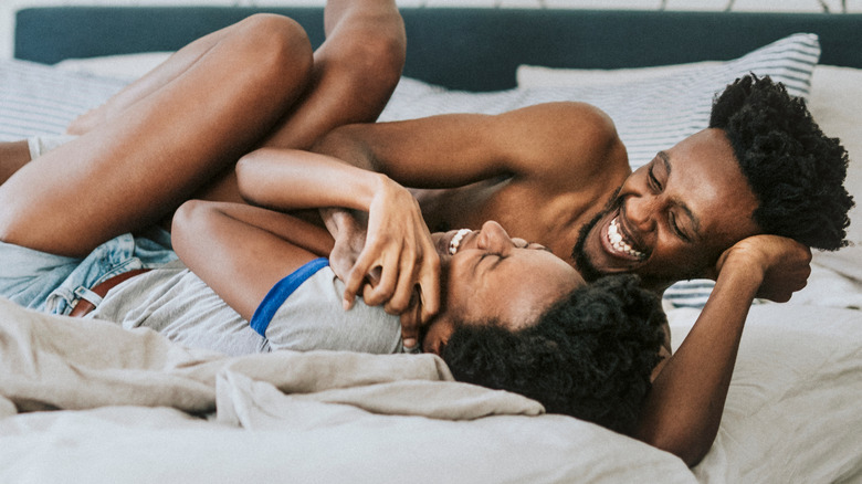 Couple laughing in bed
