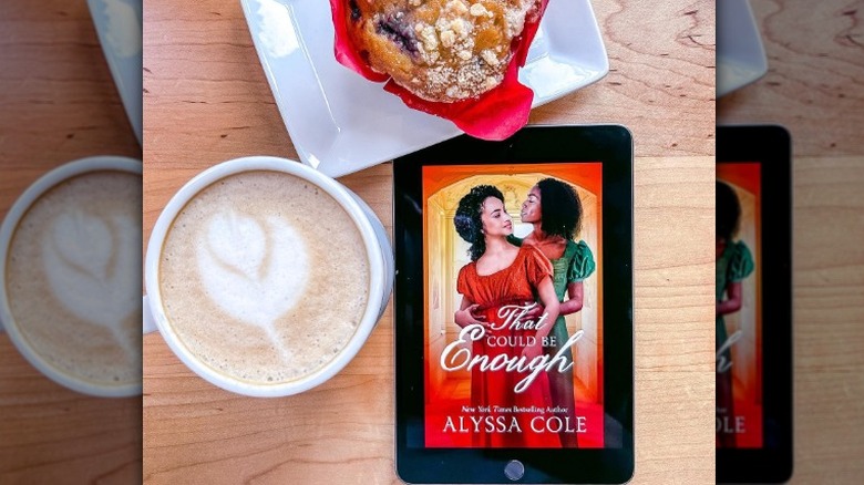 Display of coffee, muffin, and kindle on table