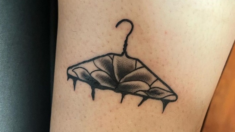 Spiked coat hanger tattoo